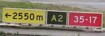 Three panels on a common frame: yellow “← 2550m”, black “A2” location, and red “35-17” runway designator.